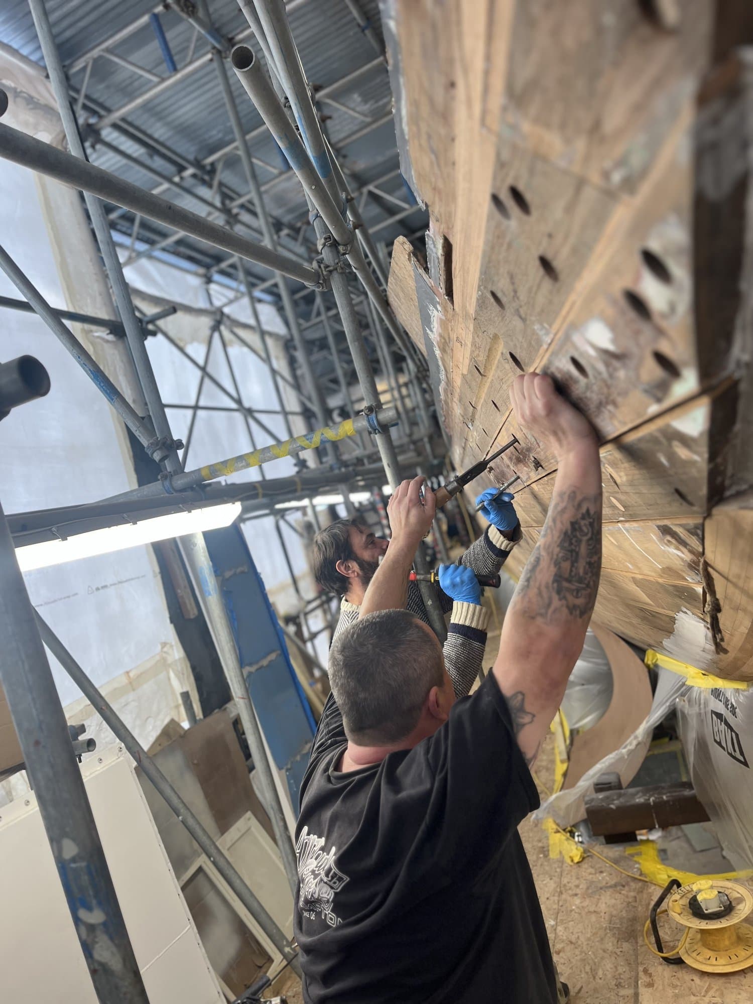 Craftsmen restoring traditional timber planking on a classic yacht